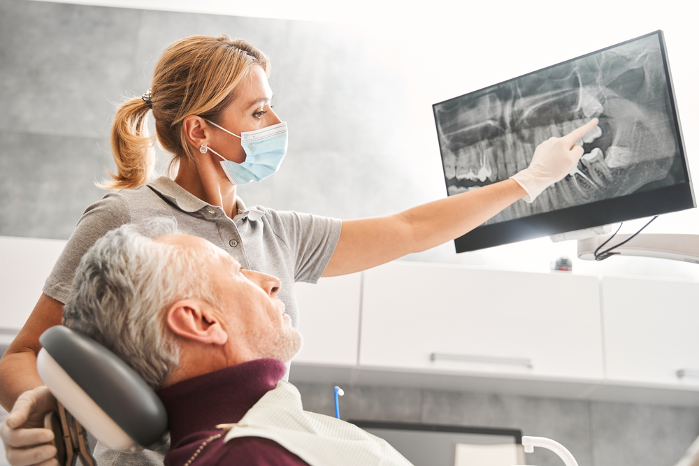 women dentist showing an older patient an xray of his teeth