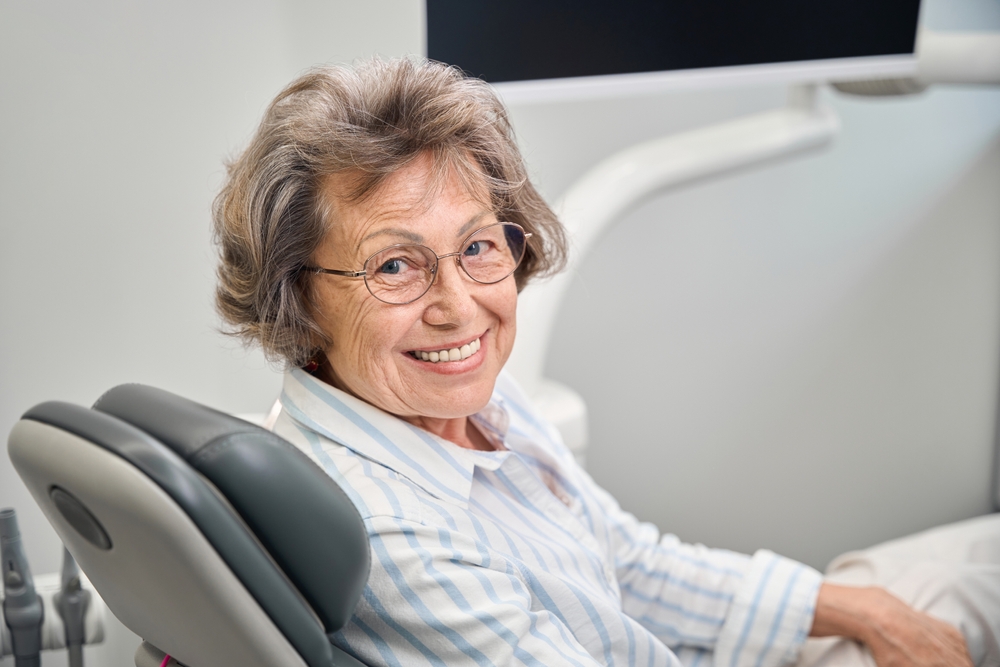 older women smiling in a dental chair